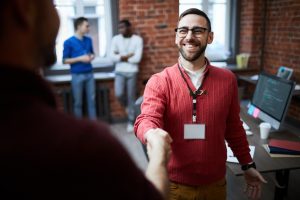 Men shaking hands in room for stakeholder engagement purpose